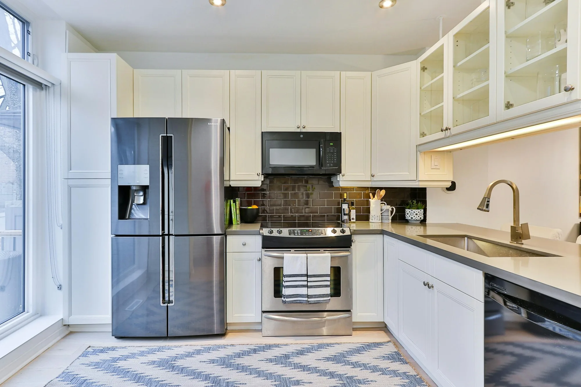 Original kitchen with dated white cabinets and laminate counters