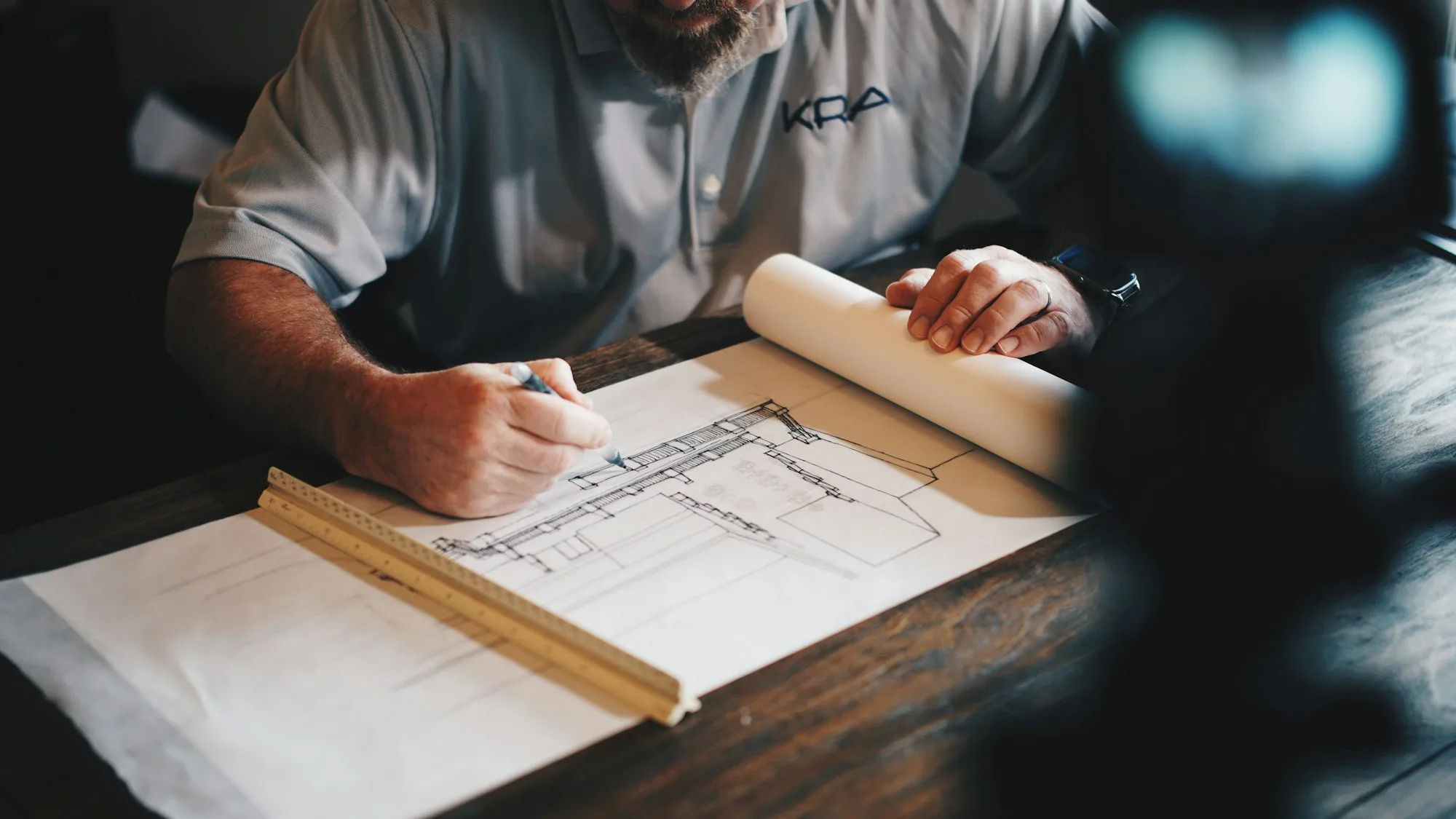 Project lead reviewing remodel drawings at a desk