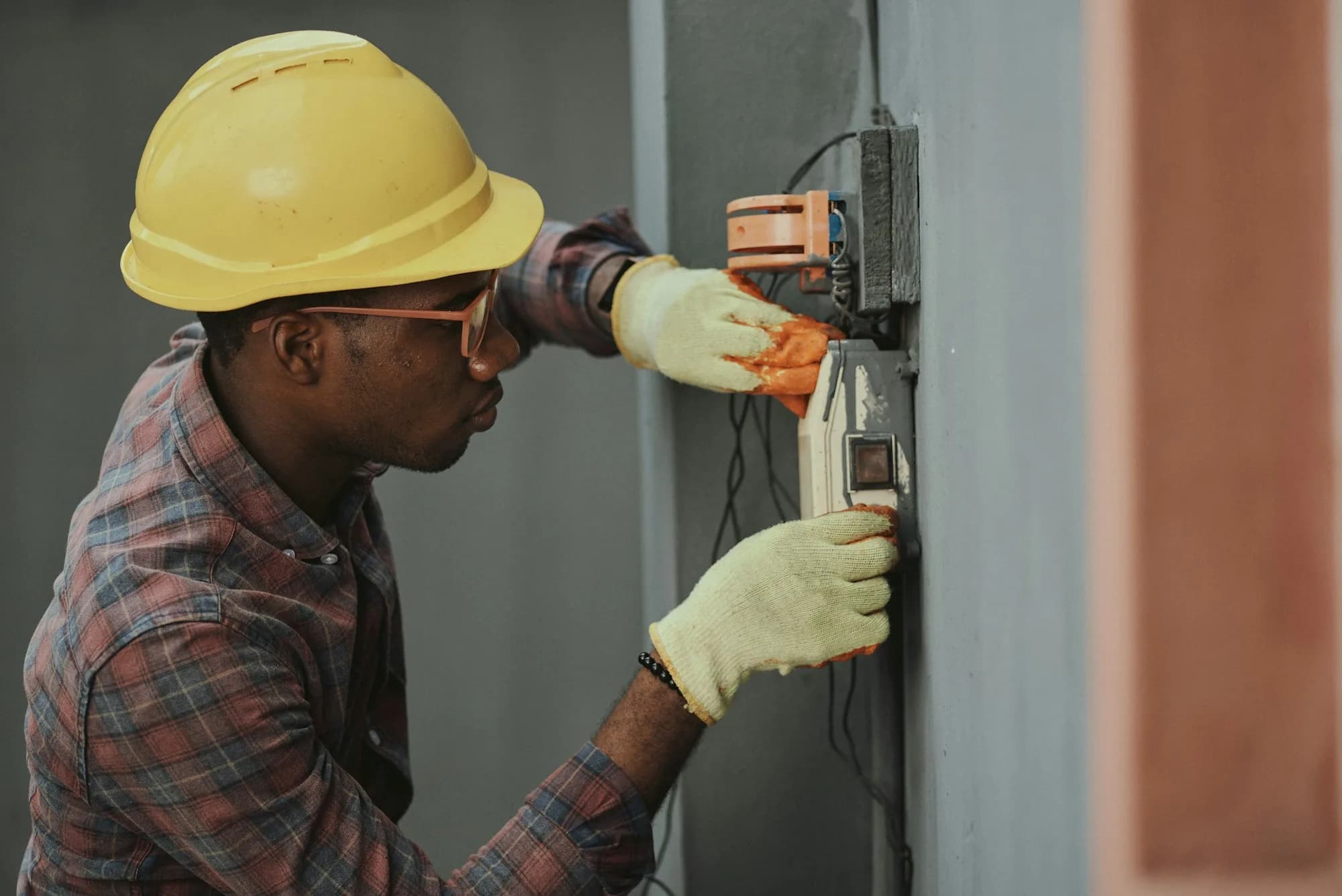 Electrician wiring a new outlet inside a home under renovation